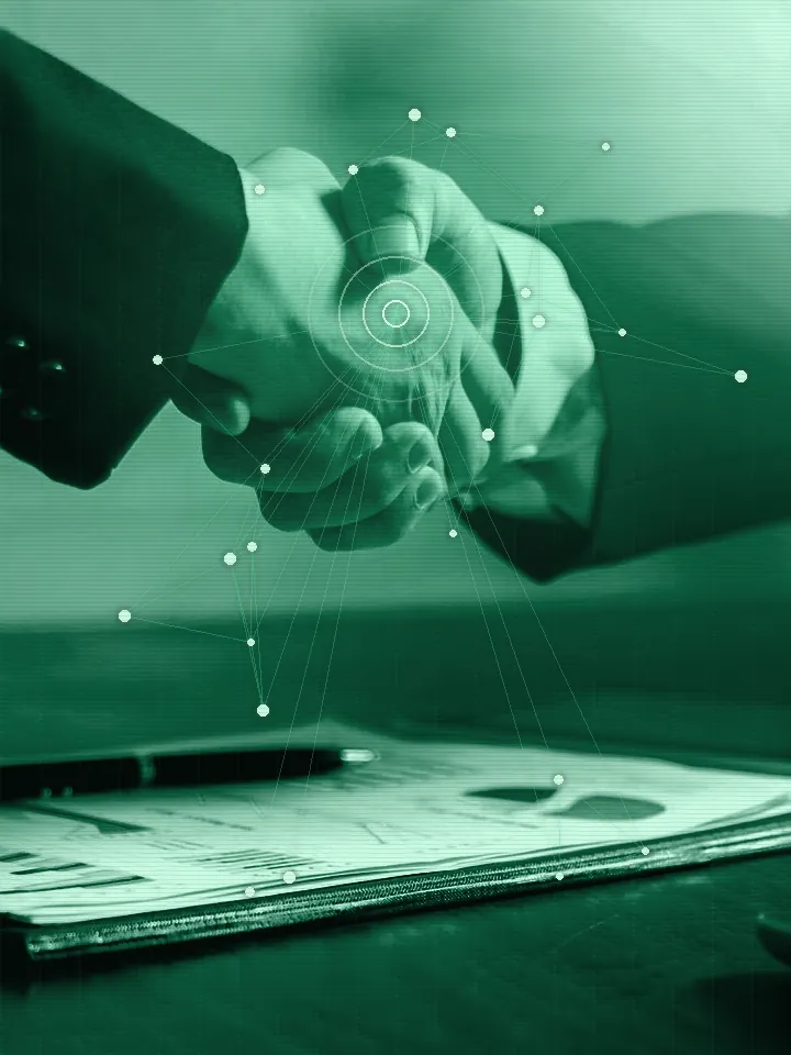 Handschlag über Projektunterlagen